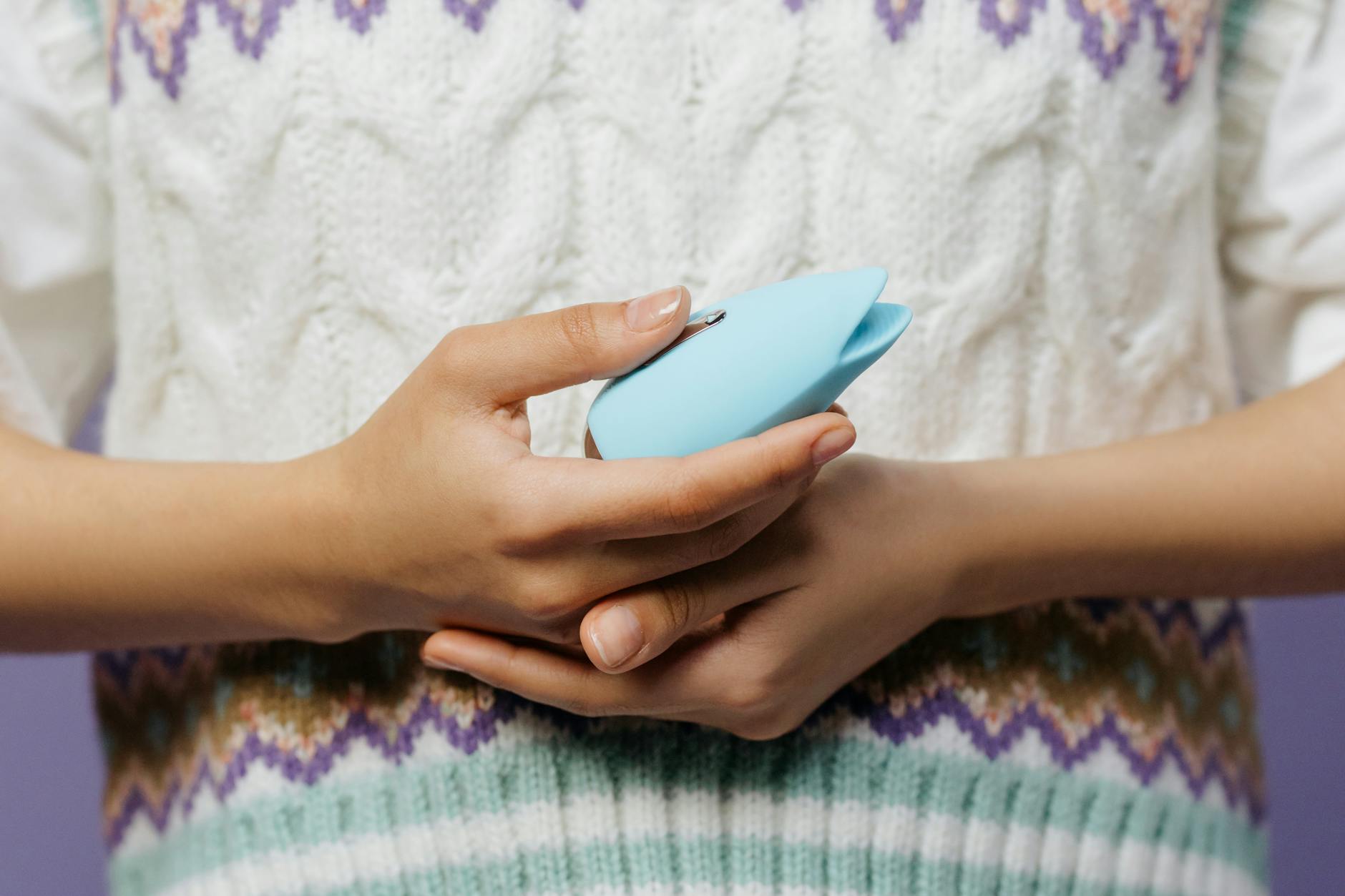 Hands holding a personal massager, representing intentional pleasure and extended intimacy sessions.